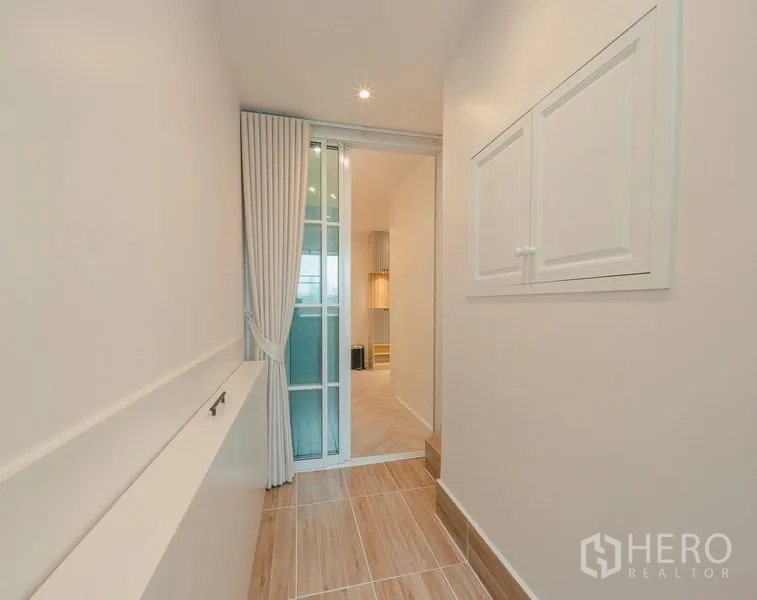Condominium for sale in Yan Nawa, Bangkok - Utility corridor with sliding glass door, curtain divider, and raised tiled floor.