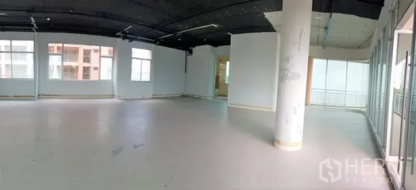 办公空间 出租在Phra Khanong, Bangkok - 转角办公楼层，立柱与环幕玻璃并带阳台出入口，适合自定义装修。