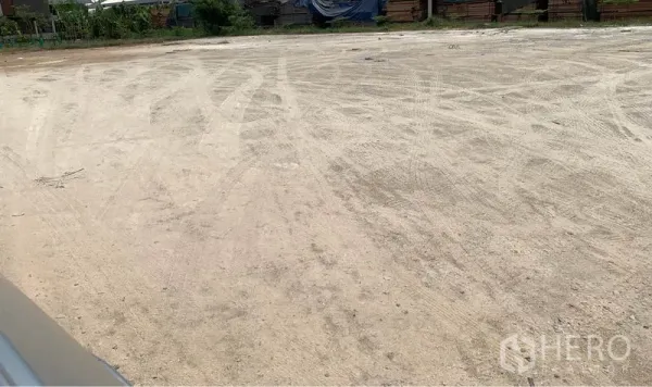 Land for rent in Lam Luk Ka, Pathum Thani - Leveled, cleared 1‑rai dirt plot in Lam Luk Ka, suitable for warehouse or yard use with greenery along the boundary.