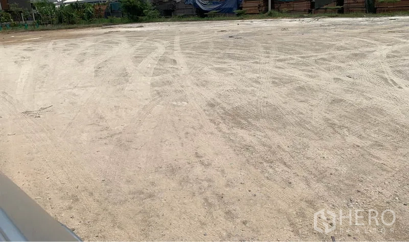 Land for rent in Lam Luk Ka, Pathum Thani - Leveled, cleared 1‑rai dirt plot in Lam Luk Ka, suitable for warehouse or yard use with greenery along the boundary.