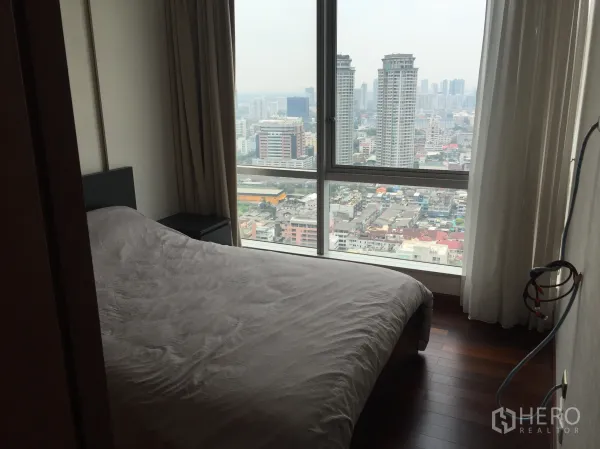 Condominium for rent in Sathon, Bangkok - High-floor bedroom with floor-to-ceiling windows and Bangkok skyline view in a Sathorn condo.