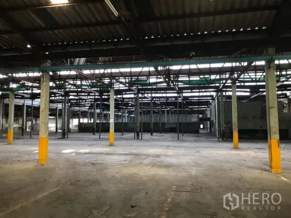 Land for rent in Phra Pradaeng, Samut Prakan - Open industrial hall with a grid of columns and skylights, ideal for storage or redevelopment.
