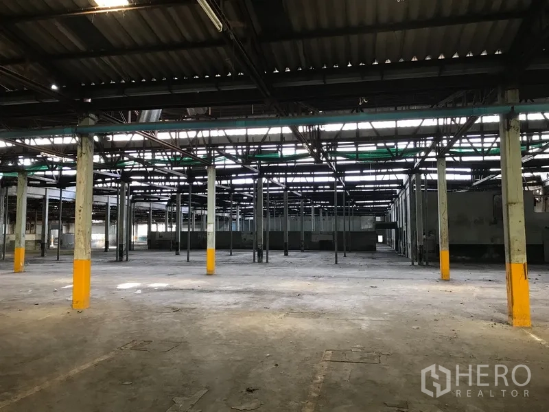 Land for rent in Phra Pradaeng, Samut Prakan - Open industrial hall with a grid of columns and skylights, ideal for storage or redevelopment.