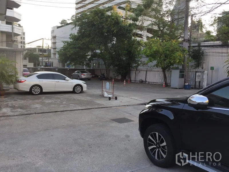 พื้นที่ขายปลีก ให้เช่าในKhlong Toei, Bangkok - ลานจอดรถสไตล์คอร์ทยาร์ดกว้าง มีต้นไม้ ประตูทางเข้า และคอนโดรายรอบ