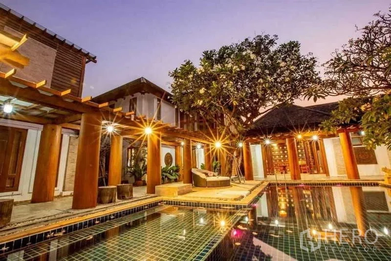 Detached House for sale in Bueng Kum, Bangkok - Dusk shot of tiled pool surrounded by pergolas and timber pavilions.