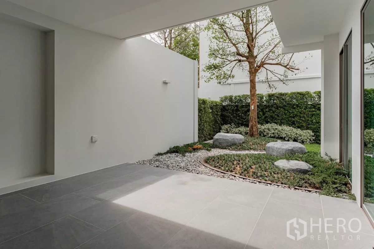 บ้าน ให้เช่าในSaphan Sung, Bangkok - เฉลียงในร่มมองสู่สวนคอร์ตยาร์ดพร้อมหินและต้นไม้