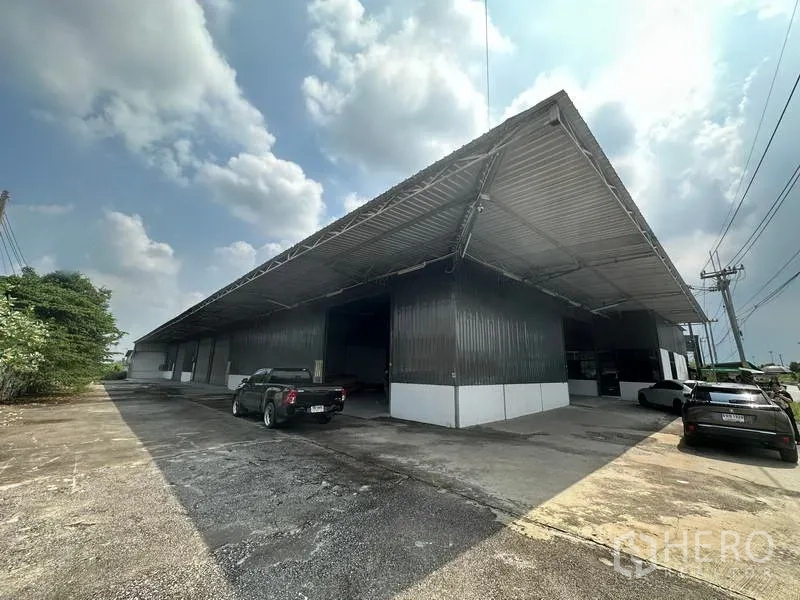 货栈 出租在Khlong Luang, Pathum Thani - 金属外墙仓库外观，带大型有顶装卸区和停车位，位于Khlong Luang。