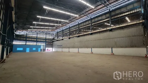 คลังสินค้า ให้เช่าในMueang Samut Prakan, Samut Prakan - มุมมองภายในไปทางประตูโหลดสินค้า มีออฟฟิศสีน้ำเงินภายในโกดัง