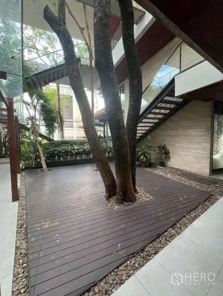 พื้นที่ขายปลีก ให้เช่าในWatthana, Bangkok - พื้นที่ดาดไม้โอบล้อมต้นไม้ ข้างแปลงต้นไม้และบันไดสมัยใหม่ในโครงการค้าปลีก
