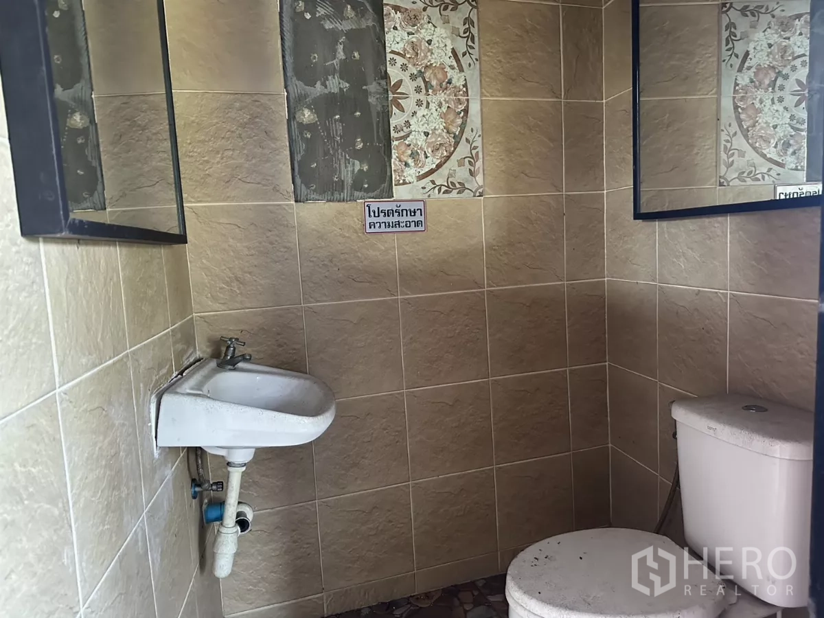 店屋 出租在Bang Na, Bangkok - 瓷砖卫生间，设坐便器、洗手盆与墙镜。