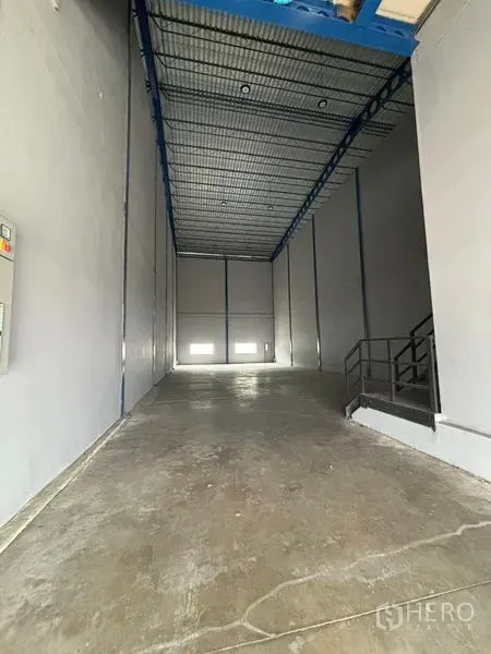 Warehouse for rent in Krathum Baen, Samut Sakhon - Tall warehouse bay with concrete floor, high steel roof and loading area.