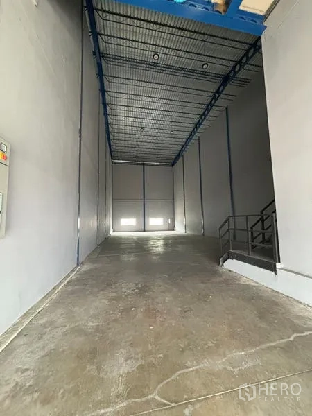 Warehouse for rent in Krathum Baen, Samut Sakhon - Tall warehouse bay with concrete floor, high steel roof and loading area.