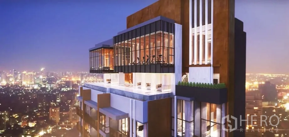 Condominium for sale in Watthana, Bangkok - Close-up of the rooftop sky lounge and glass-walled fitness room with panoramic Bangkok city lights.