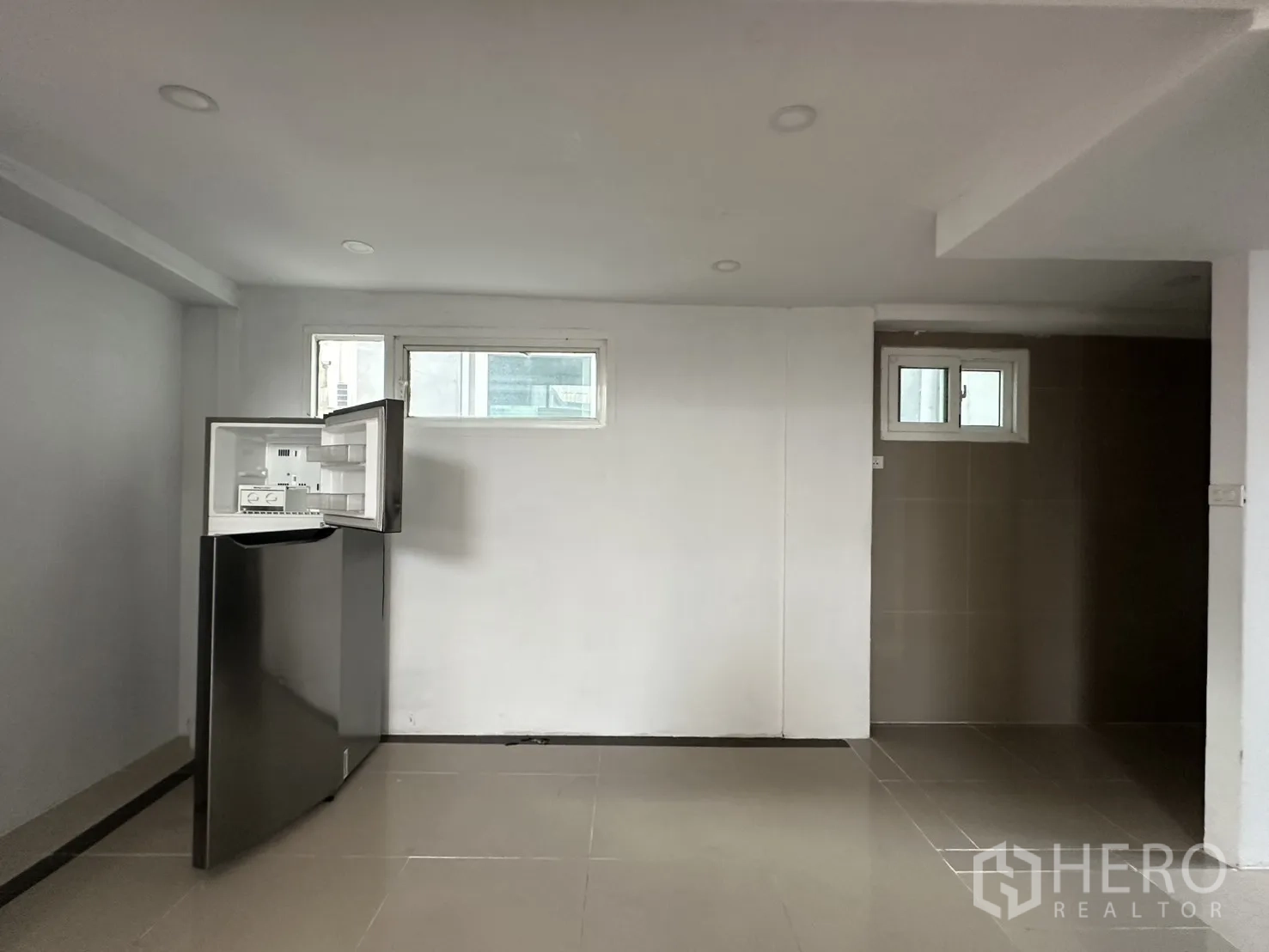 Home Office for rent in Watthana, Bangkok - Ground-floor multipurpose room with small windows and a refrigerator.