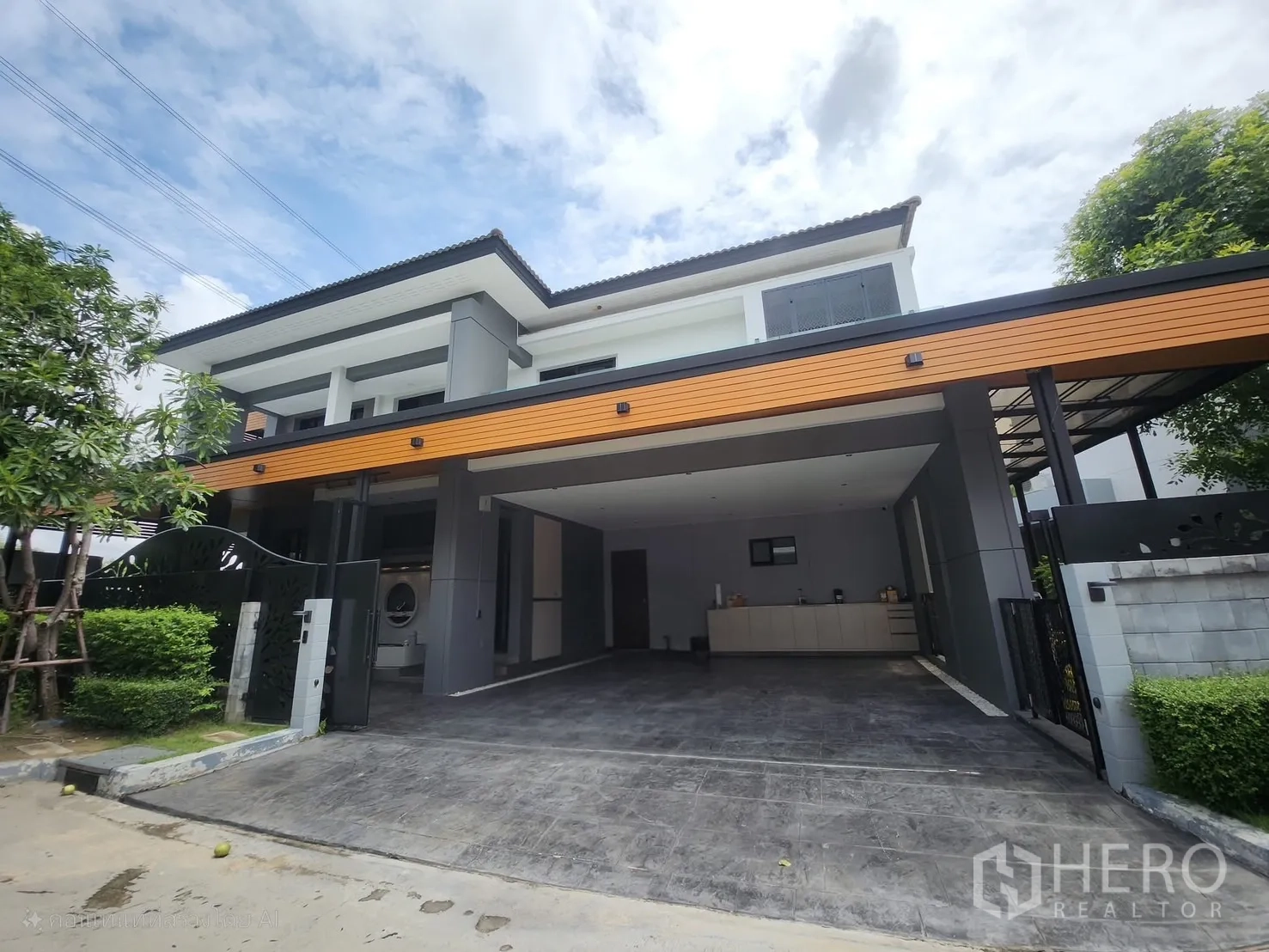 Detached House for rent in Bang Phli, Samut Prakan - Front exterior of a modern two-storey detached house with wide gated driveway and covered parking.