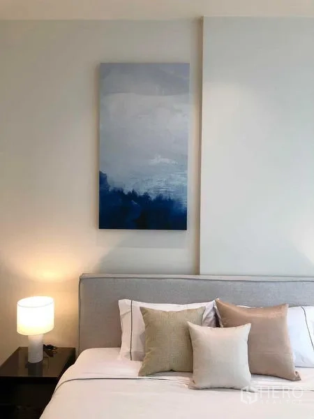 Condominium for rent - Detail of the master bed with neutral pillows and a modern bedside lamp.