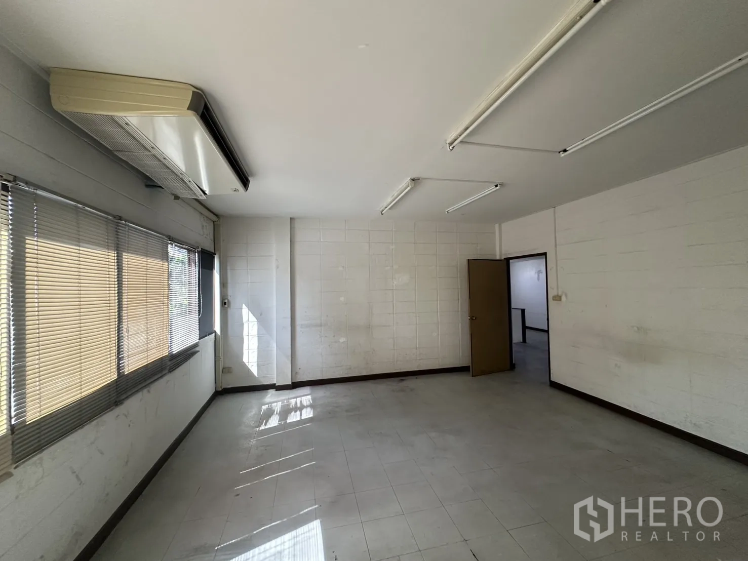 Warehouse for rent in Bang Na, Bangkok - Bright office room with blinds and split-type air conditioner.