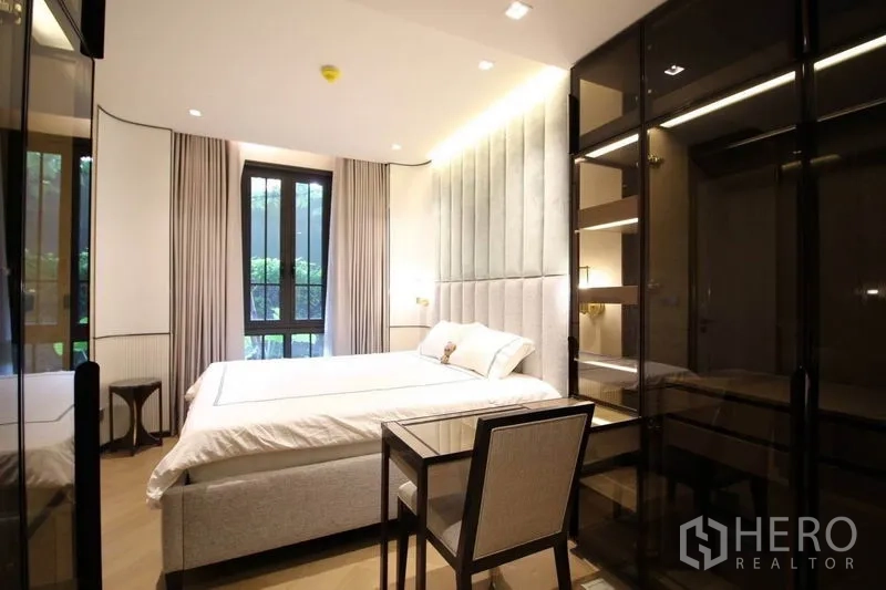 Condominium for rent in Watthana, Bangkok - Bedroom corner showing glass wardrobes, writing desk and a large window with leafy outlook.