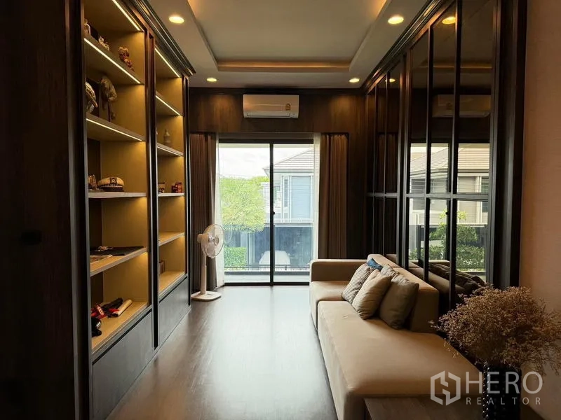 Detached House for rent in Bang Kapi, Bangkok - Upper family lounge with display shelves, sofa and sliding door to a balcony.