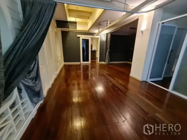 店屋 出租在Khlong Toei, Bangkok - 开放式大房间，抛光木地板，外露梁，带玻璃隔断。