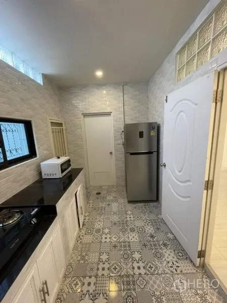 ทาวน์เฮาส์ ให้เช่าในPhra Khanong, Bangkok - มุมครัวอีกด้าน หน้าต่างติดเหล็กดัด ตู้เย็นและไมโครเวฟบนเคาน์เตอร์