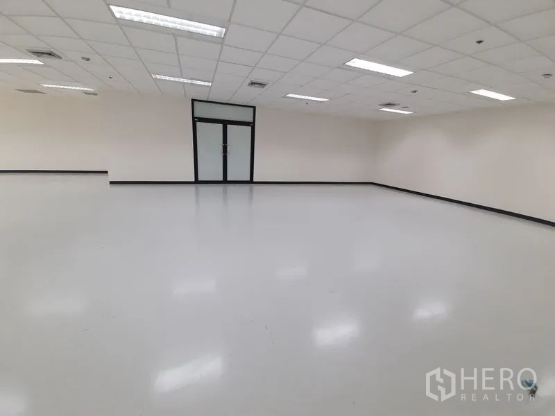 办公空间 出租在Bang Rak, Bangkok - 空置办公室内景，面对玻璃入口门，白墙与吊顶灯。