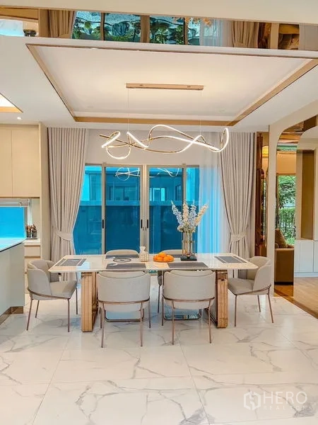 Detached House for sale in Bang Kapi, Bangkok - Six-seat dining room with sliding glass doors to the garden and a contemporary pendant light.