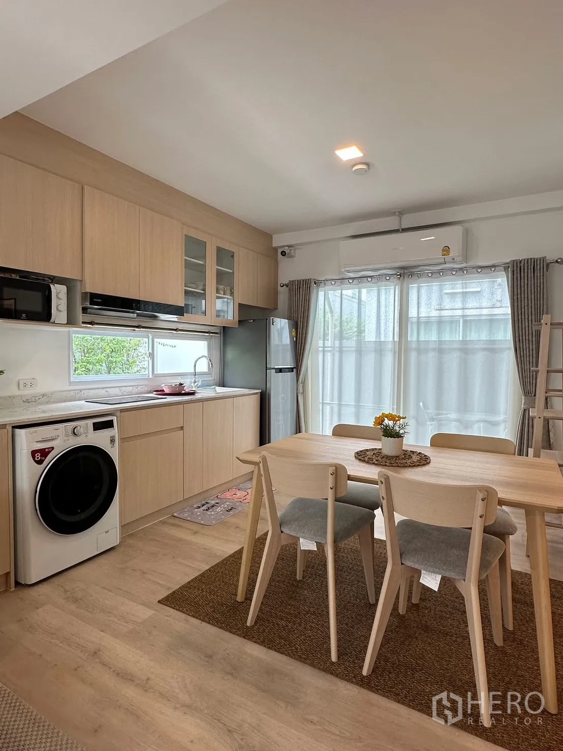 联排别墅 for rent in Prawet, Bangkok - 厨房与餐区一体，带定制橱柜、洗衣机与餐桌椅。