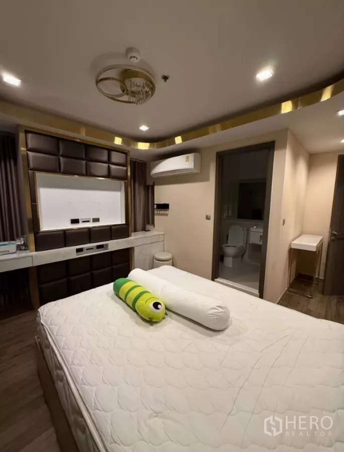 Condominium for rent in Chatuchak, Bangkok - Primary bedroom with built-in headboard, dressing counter, and en-suite bathroom access.