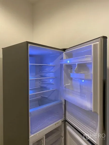 Condominium for rent - Open two-door refrigerator with blue interior light in the condo kitchen.