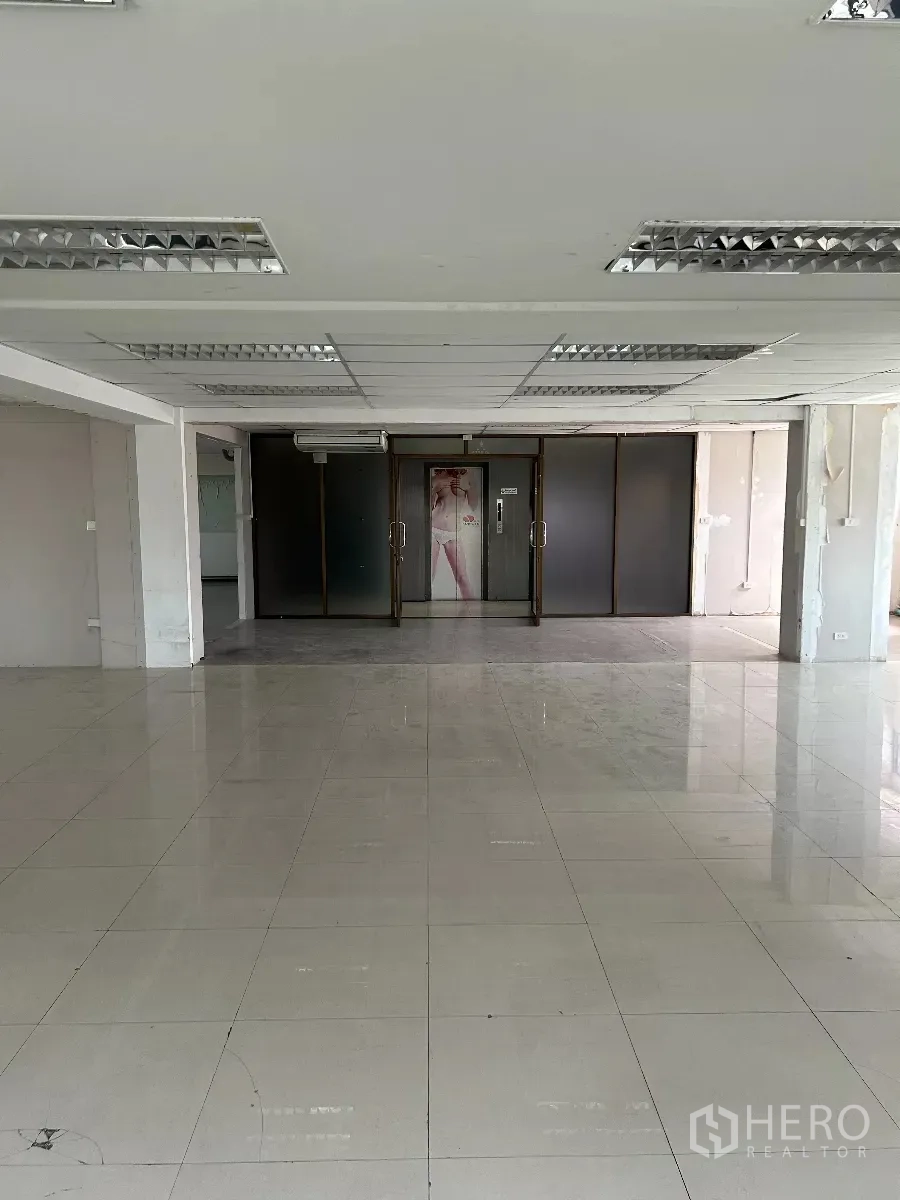 办公空间 出租在Din Daeng, Bangkok - 从室内望向玻璃入口门，天花配荧光灯。