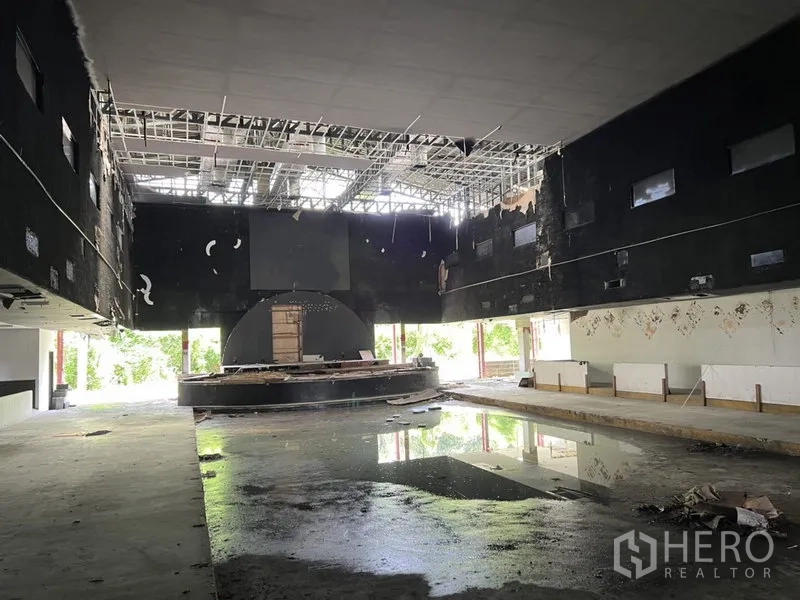 货栈 出租在Bang Kapi, Bangkok - 宽阔高挑大厅，裸露吊顶网格与地面积水，空间开阔。