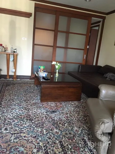 คอนโด ให้เช่าหรือขายในWatthana, Bangkok - พื้นที่นั่งเล่นพร้อมพรมลาย โซฟาเข้ามุม และประตูบานเลื่อนไม้