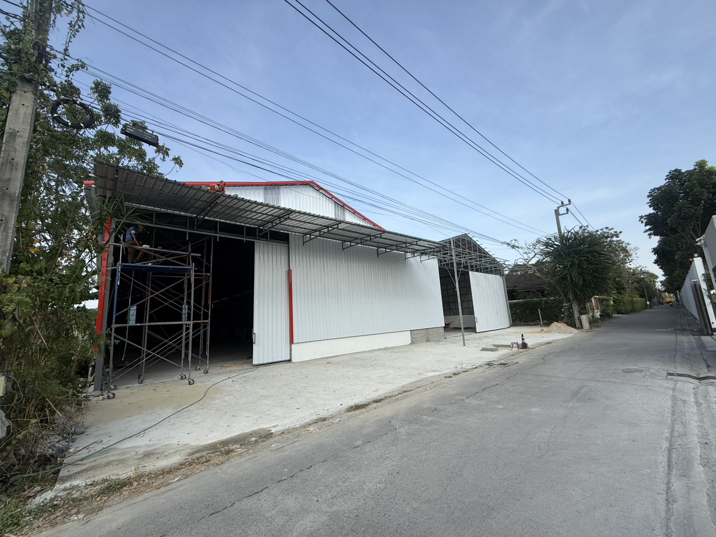 Warehouse for rent in Saphan Sung, Bangkok - Street-side view of warehouse facade with canopy and wide entrance under construction in Saphan Sung, Bangkok.