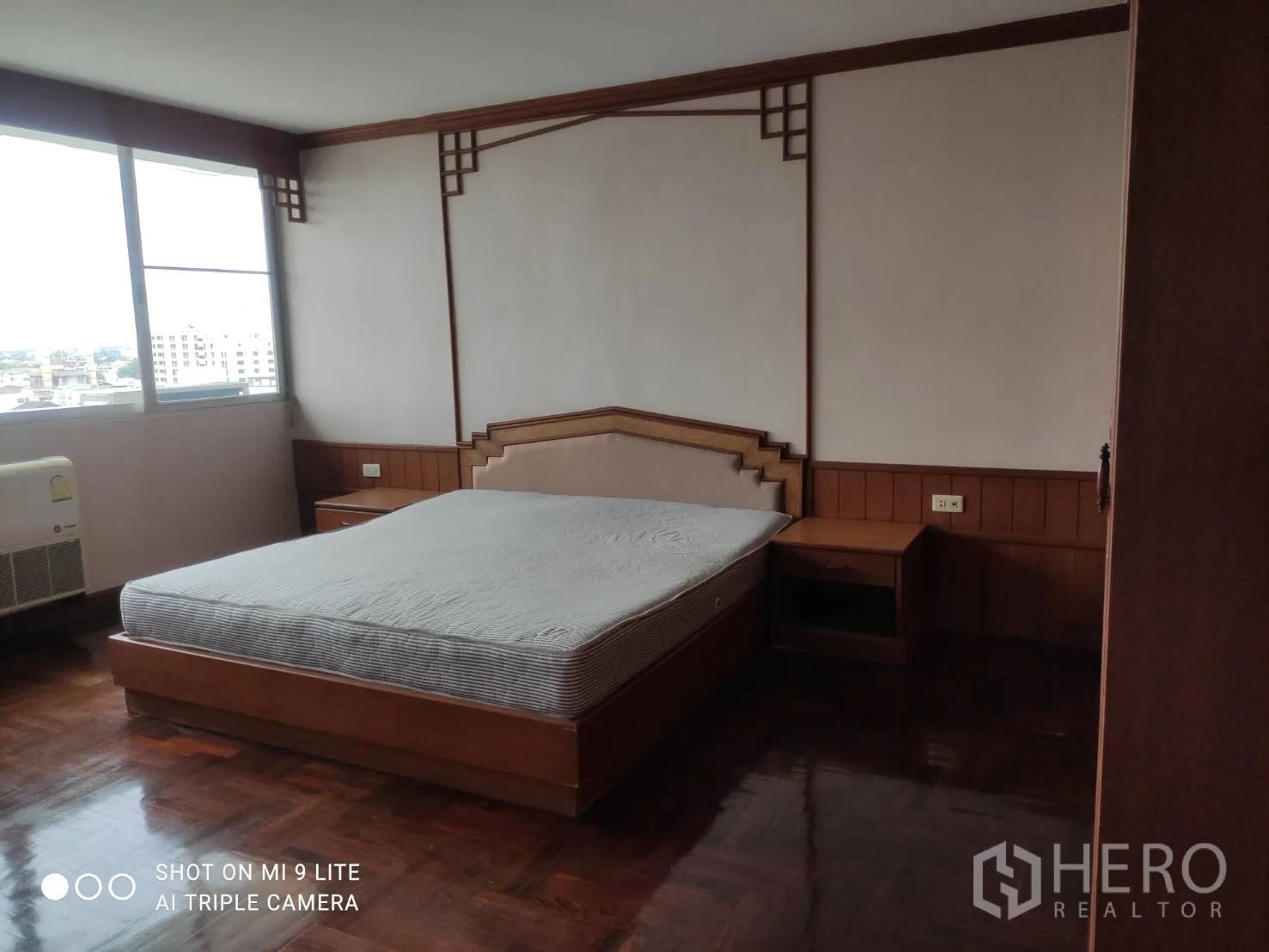 อพาร์ทเมนท์ ให้เช่าในWatthana, Bangkok - ห้องนอนมุมพร้อมหน้าต่างบานใหญ่ หัวเตียงไม้ และพื้นปาร์เกต์