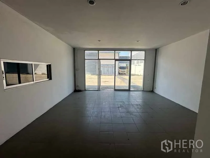 货栈 出租在Bang Bua Thong, Nonthaburi - 仓库内办公间，玻璃入口可见外部装卸区