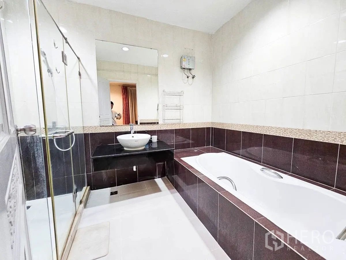 联排别墅 for rent in Yan Nawa, Bangkok - 浴室设浴缸、玻璃淋浴间与台上盆黑色台面。