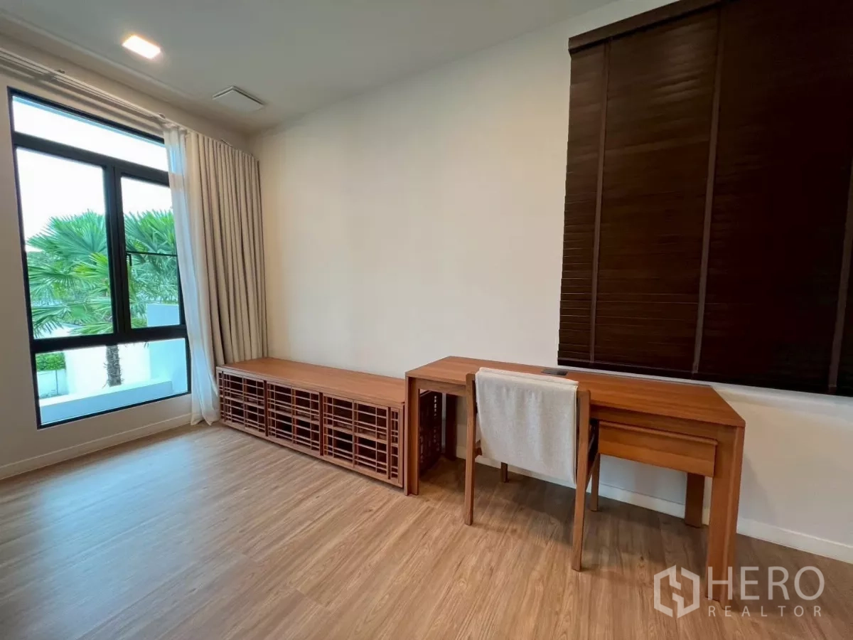 Detached House for rent in Samut Prakan - Master suite corner with desk and storage bench by the window.