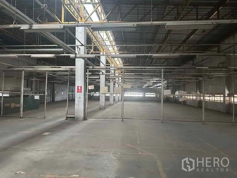 Factory for rent in Khlong Luang, Pathum Thani - Production hall with steel trusses and mesh partitions inside the factory