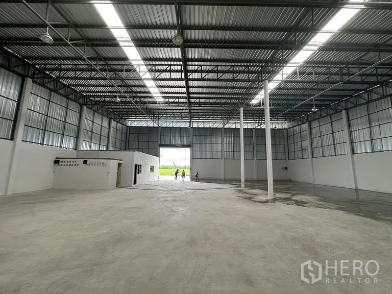 Warehouse for rent in Sai Noi, Nonthaburi - Warehouse bay facing a large loading door with natural light and high clearance.
