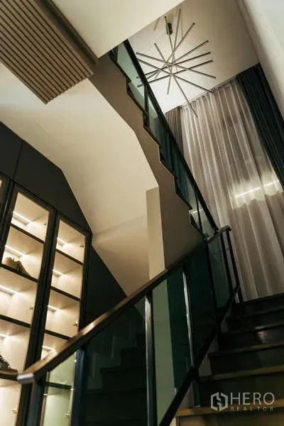 บ้าน ขายในSai Mai, Bangkok - บันไดร่วมสมัยราวกระจก ผ้าม่านสูง และตู้โชว์ไฟในตัวใต้โคมระย้า