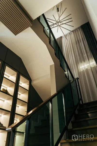 บ้าน ขายในSai Mai, Bangkok - บันไดร่วมสมัยราวกระจก ผ้าม่านสูง และตู้โชว์ไฟในตัวใต้โคมระย้า