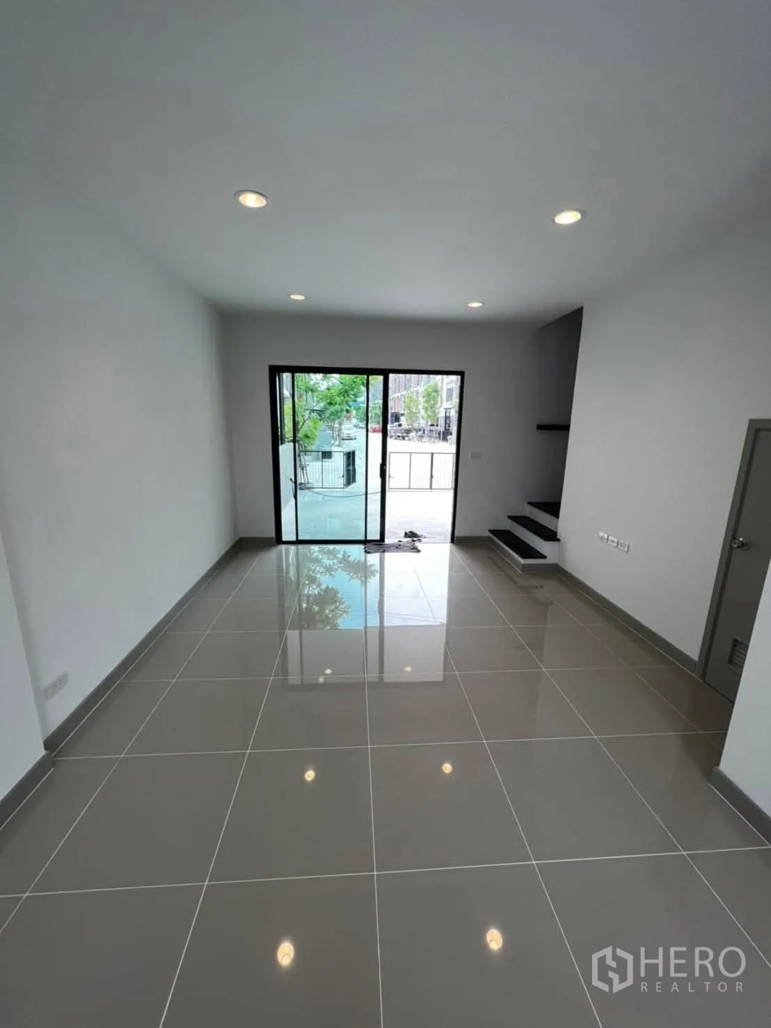 Townhouse for rent in Bang Khen, Bangkok - Wide ground-floor living room with recessed lights and front-facing sliding doors.
