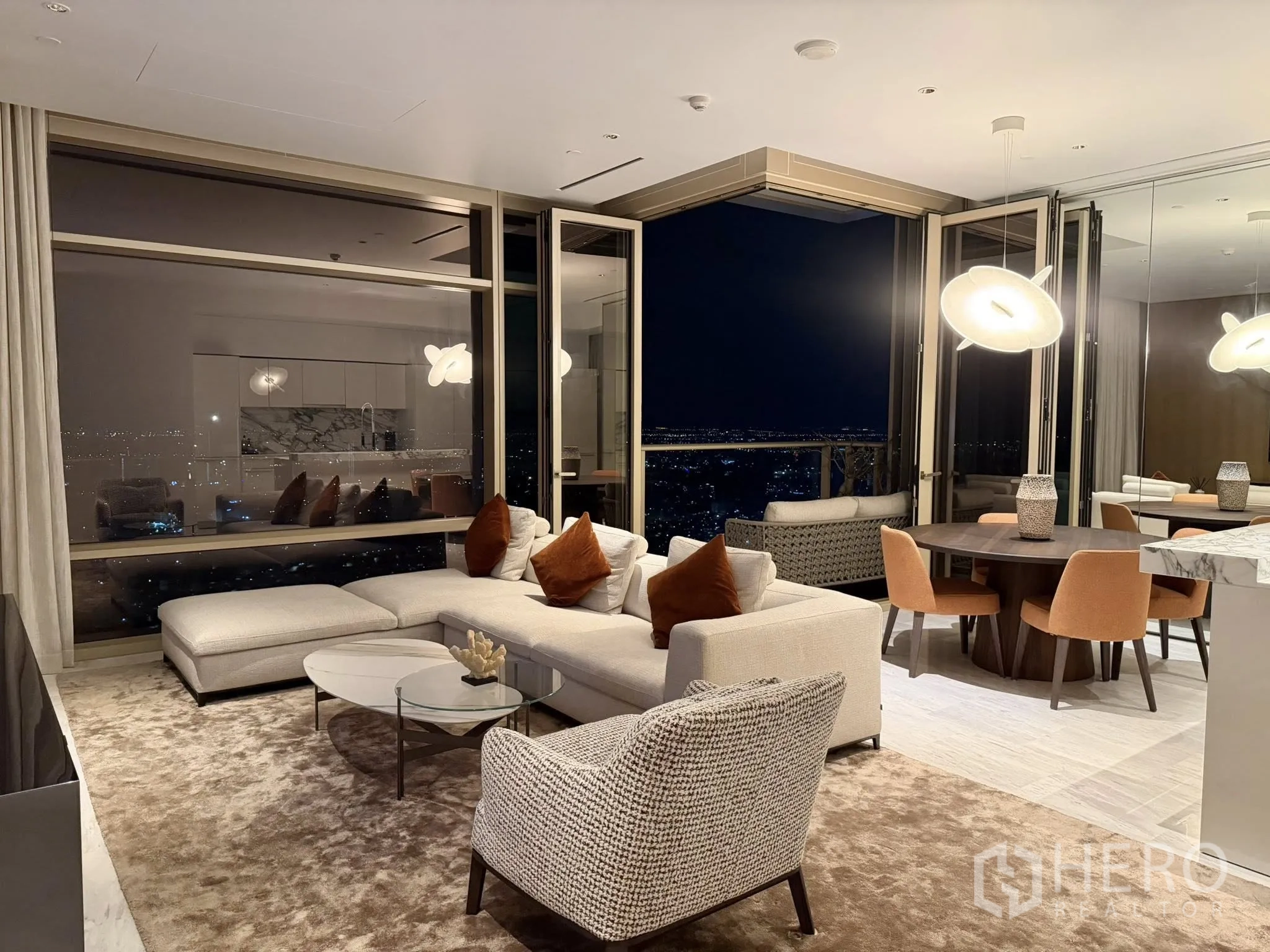 คอนโด for rent in Sathon, Bangkok - ห้องนั่งเล่นและรับประทานอาหารแบบเปิดโล่ง มีกระจกเต็มบาน ประตูสู่ระเบียง โคมไฟโมเดิร์น และวิวเมืองยามค่ำคืน