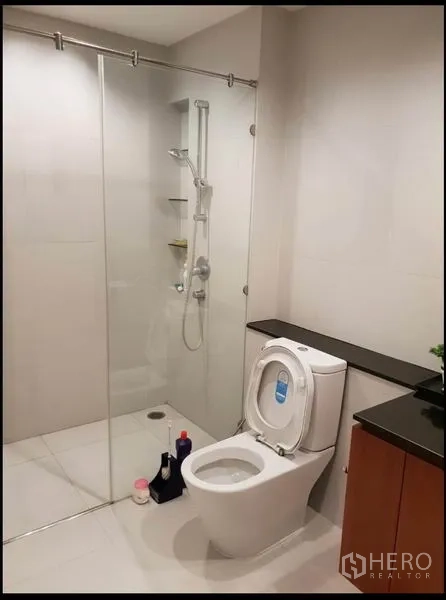 公寓 出租在Sathon, Bangkok - 现代卫浴，玻璃淋浴房、坐便器与台面洗手盆。