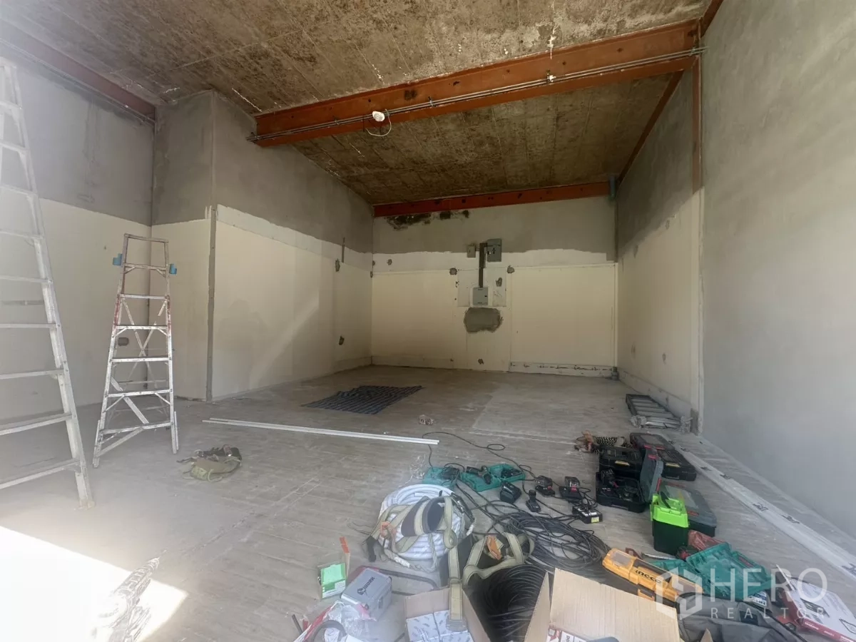 Retail Space for rent in Bang Na, Bangkok - Unfurnished retail unit under renovation with high ceiling, exposed beams, ladders and tools across an open-plan floor.