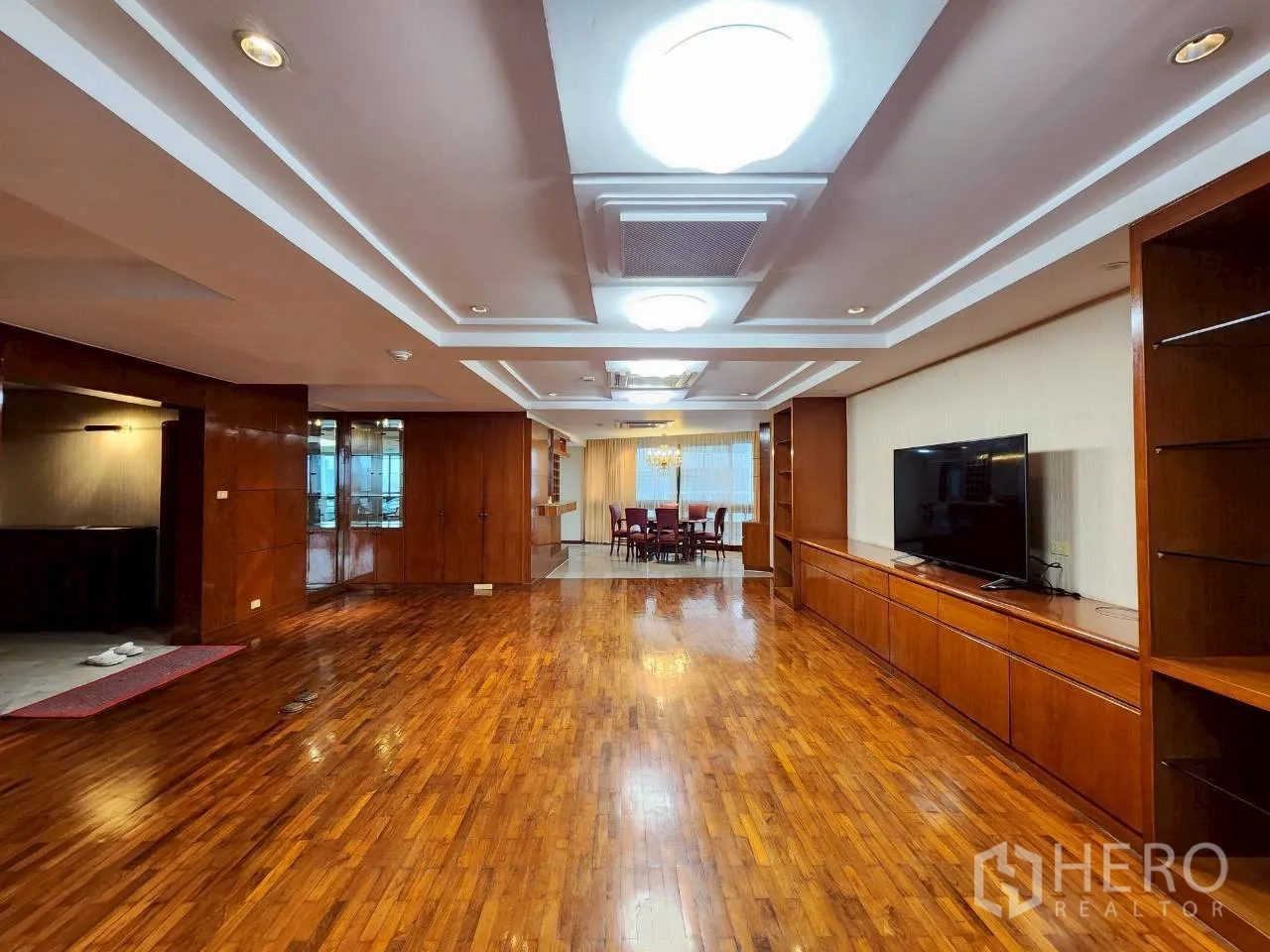 คอนโด ให้เช่าในKhlong Toei, Bangkok - โถงรับแขกเชื่อมพื้นที่ทานอาหาร ตู้ไม้บิวท์อิน และฝ้าหลุมพร้อมไฟสว่างบนพื้นไม้เงางาม