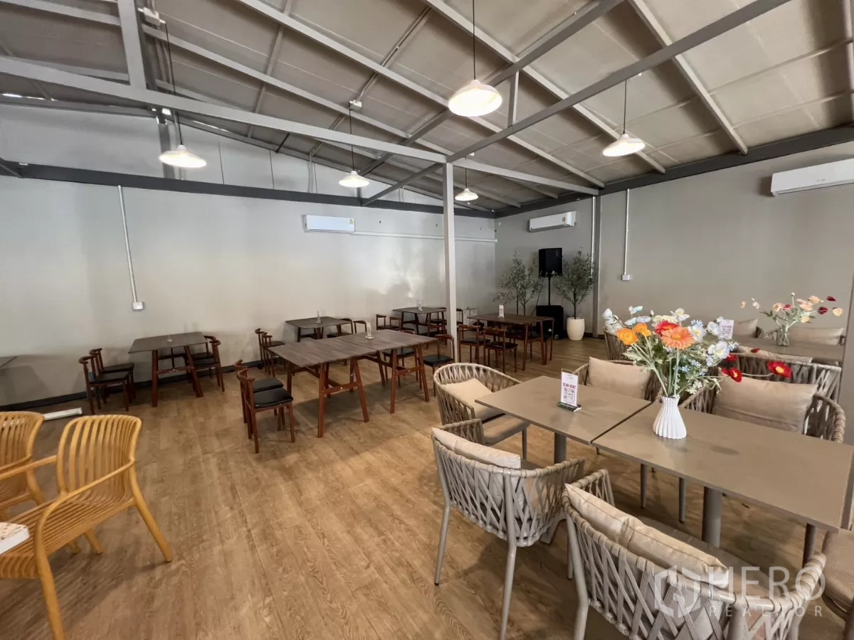 พื้นที่ขายปลีก ให้เช่าในKhlong Toei, Bangkok - ฮอลล์สไตล์คาเฟ่ทันสมัย มีโคมแขวน แอร์ พื้นลายไม้ และชุดโต๊ะเก้าอี้โทนกลาง.