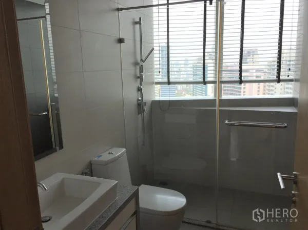 คอนโด ให้เช่าในKhlong Toei, Bangkok - ห้องน้ำโมเดิร์นพร้อมฉากกั้นอาบน้ำกระจก อ่างล้างหน้า และหน้าต่างวิวสกายไลน์.