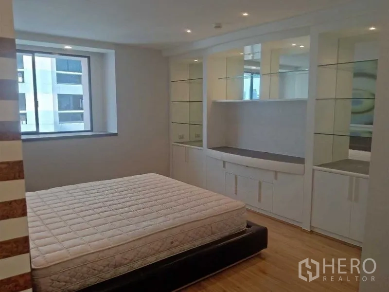 คอนโด ให้เช่าในKhlong Toei, Bangkok - ห้องนอนพร้อมตู้บิวท์อินสีขาว ชั้นกระจกโชว์ของ และหน้าต่าง